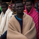 Refugees and migrants wait on deck of the Spanish NGO Proactiva Open Arms rescue vessel Golfo Azzurro to disembark after being rescued off Libyan coast north of Sabratha on Feb. 19, 2017, in Pozzallo, Italy. (David Ramos/Getty Images)